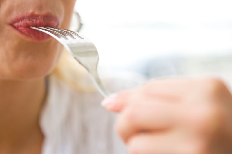 Mujer haciendo un ejercicio de comer con tenedor