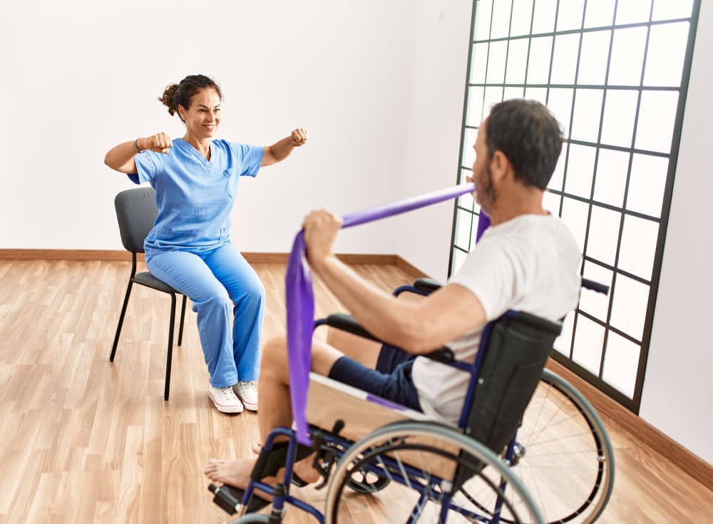 ejercicio terapeutico con banda elastica en silla de ruedas